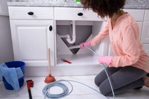 Homeowner Fixing Her Kitchen Clogged Sink